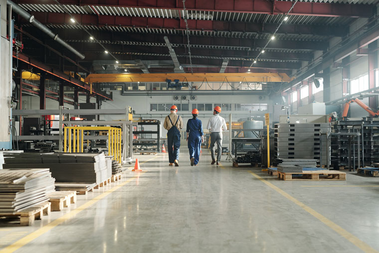 rear-view-three-technicians-engineers-industrial-plant-workwear-leaving-workshop-end-working-day